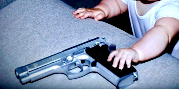 Bimbo in classe alle elementari con la pistola vera per mostrarla ai compagni.