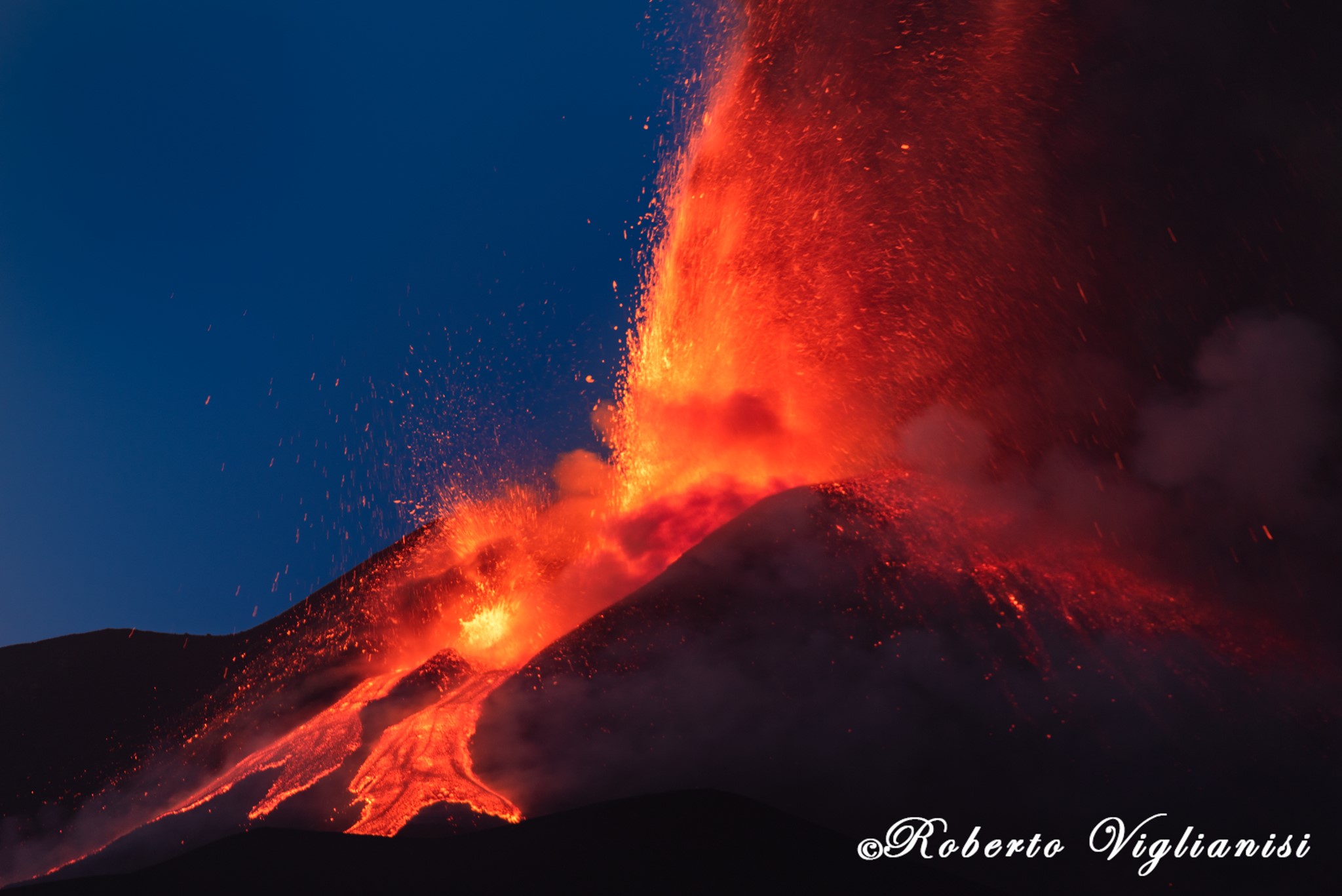 Etna irrequieta: fontana di lava da tre bocche del cratere di Sud-Est, nube alta 7 km